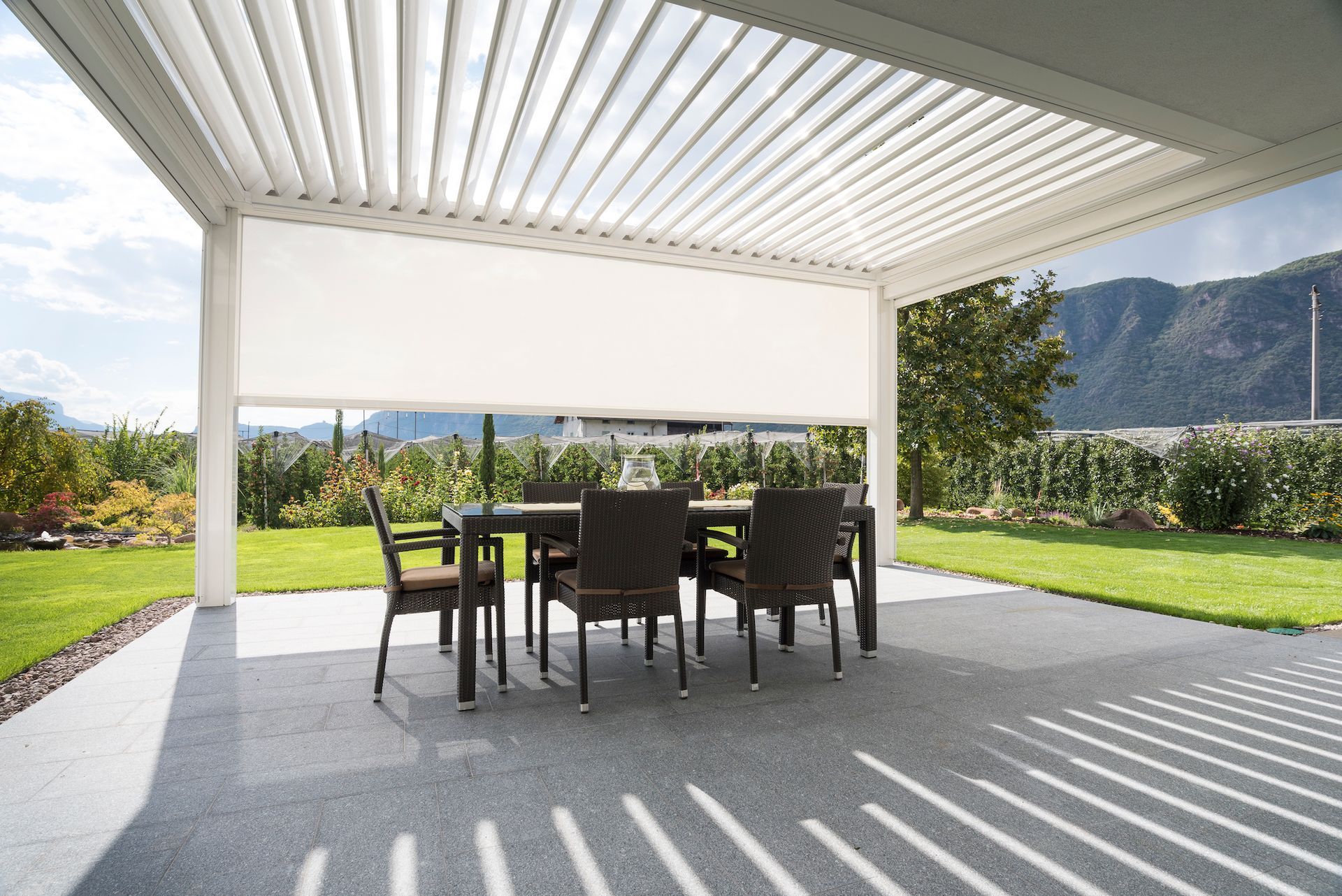 A patio with a table and chairs under a pergola - Freehold, NJ - Awning Design Inc