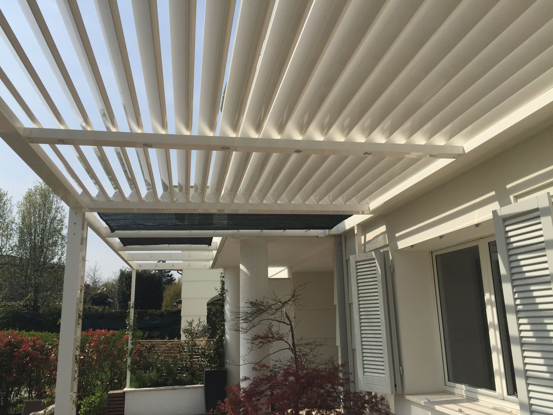 A white pergola is sitting on top of a white house - Freehold, NJ - Awning Design Inc