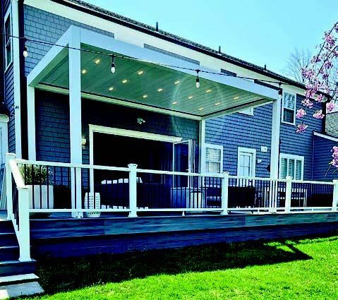 A blue house with a white deck and a white railing - Freehold, NJ - Awning Design Inc