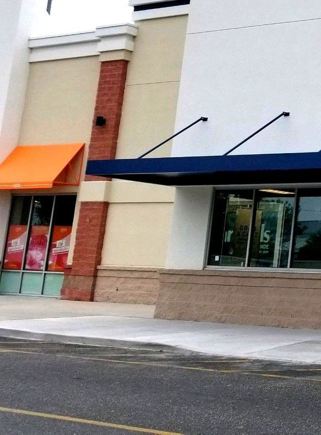A store front with an orange awning and a blue awning - Freehold, NJ - Awning Design Inc