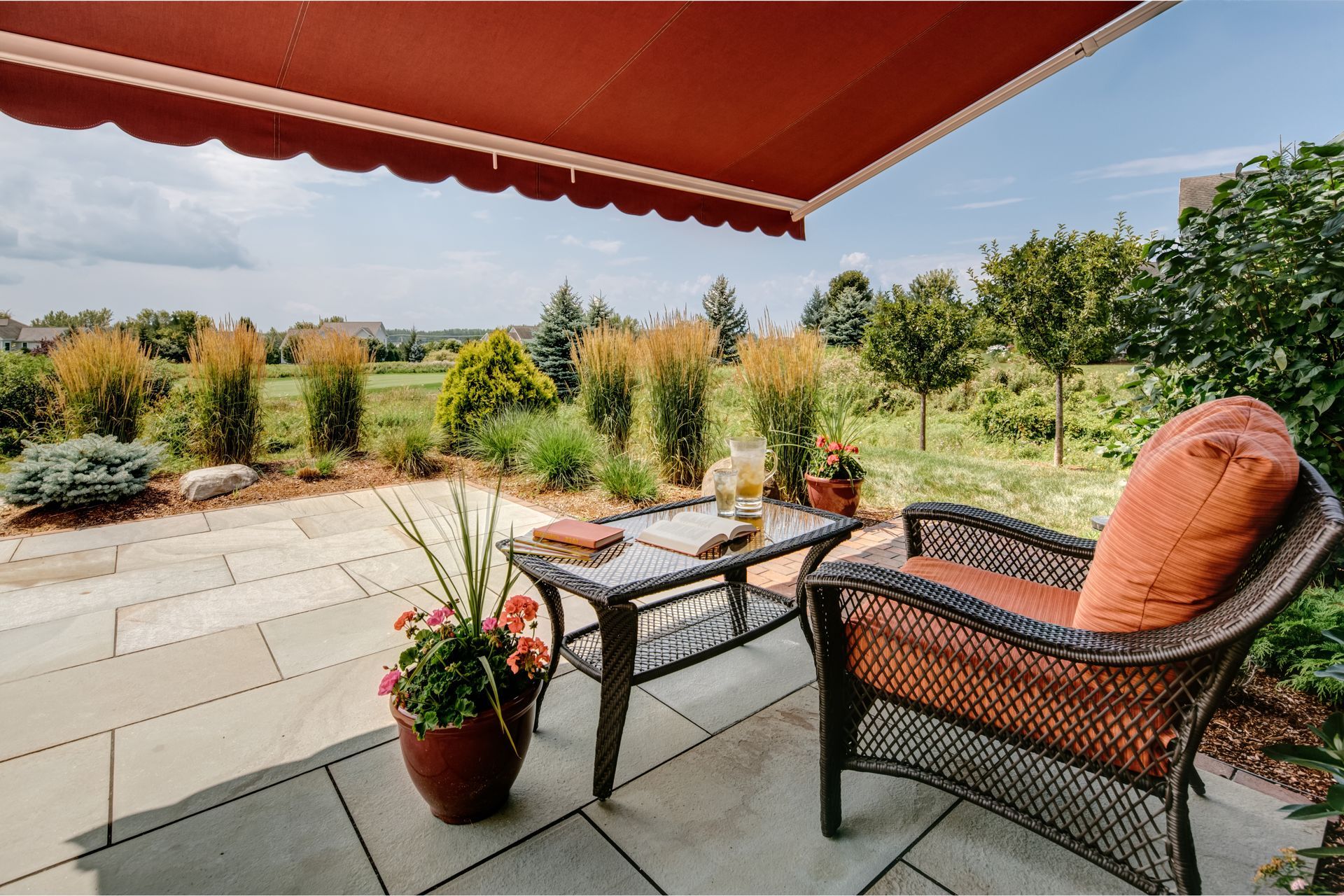 A patio with a chair and a table under an awning - Freehold, NJ - Awning Design Inc