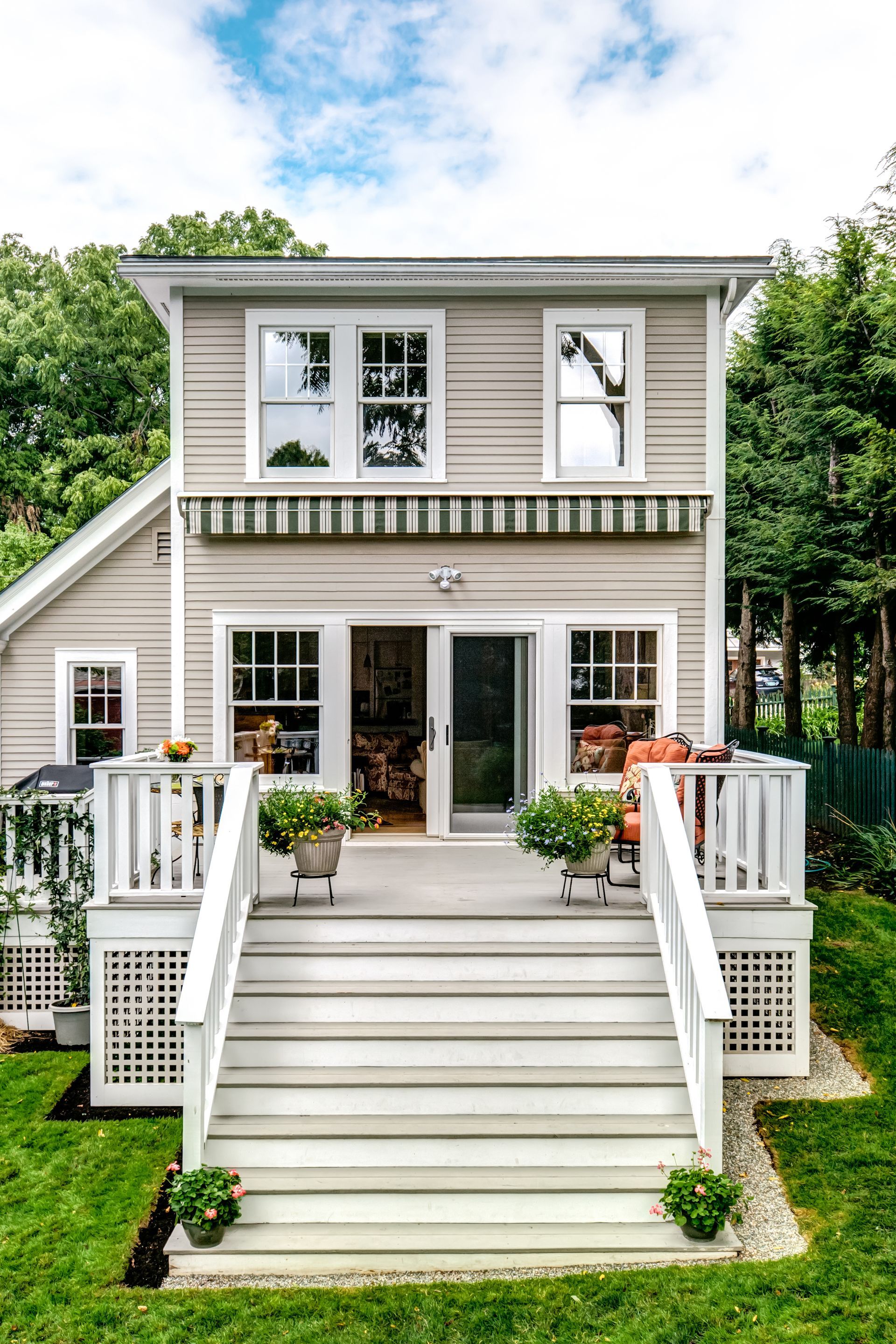 A small house with a deck and stairs leading to it - Freehold, NJ - Awning Design Inc