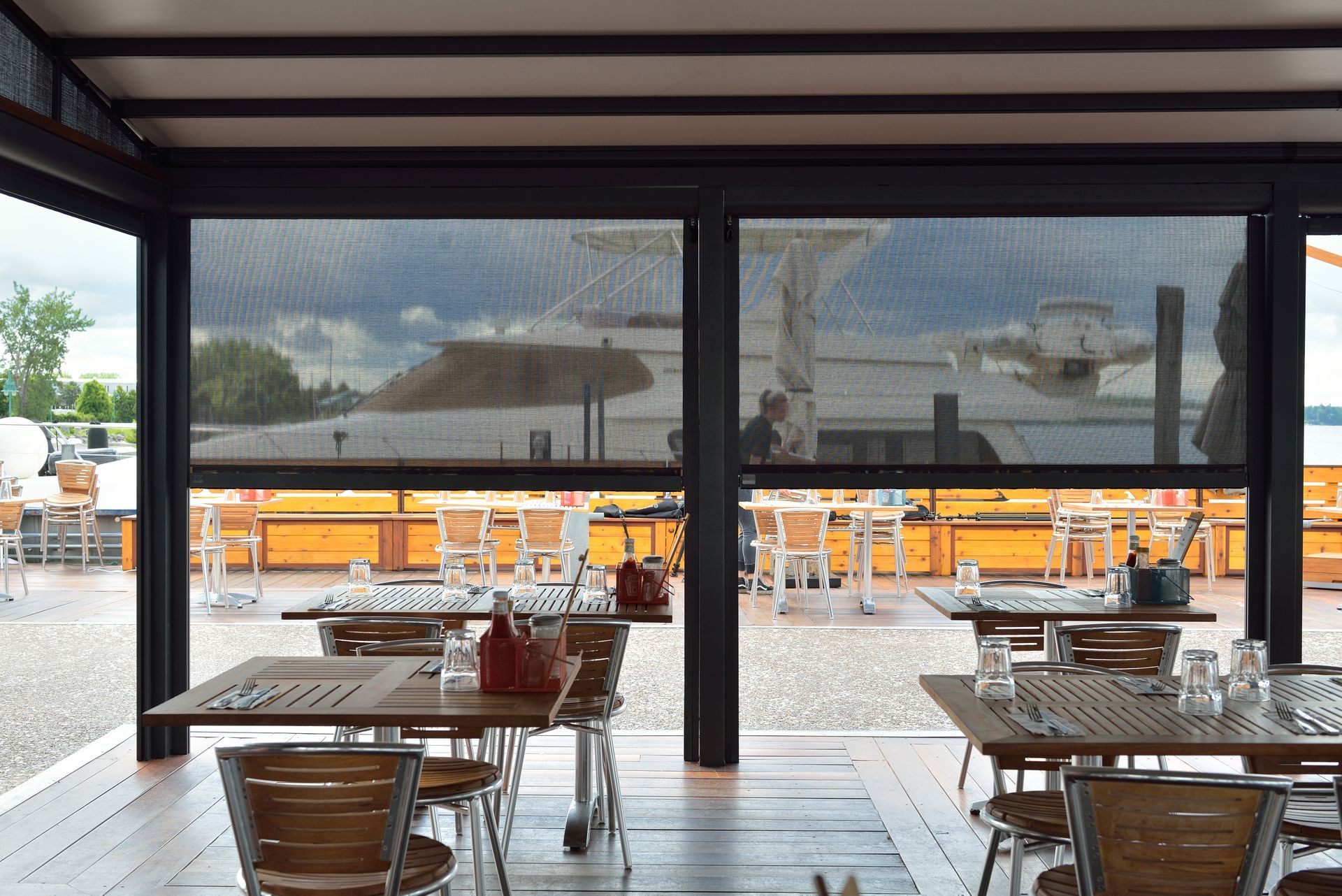 A restaurant with tables and chairs and a view of the water - Freehold, NJ - Awning Design Inc