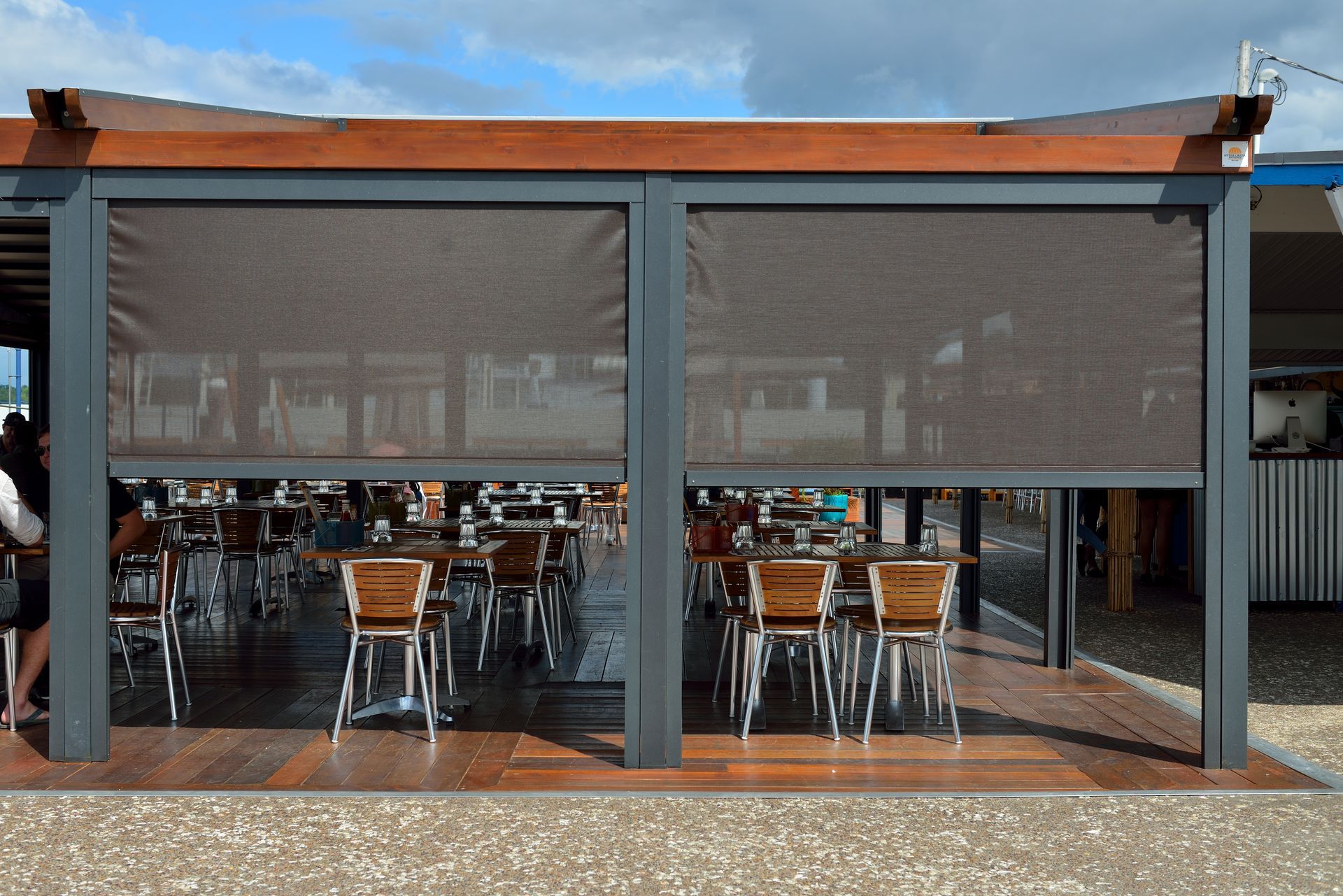 A restaurant with tables and chairs under a canopy with screens - Freehold, NJ - Awning Design Inc