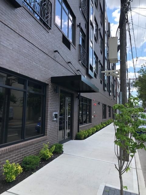 A brick building with a canopy over the entrance - Freehold, NJ - Awning Design Inc
