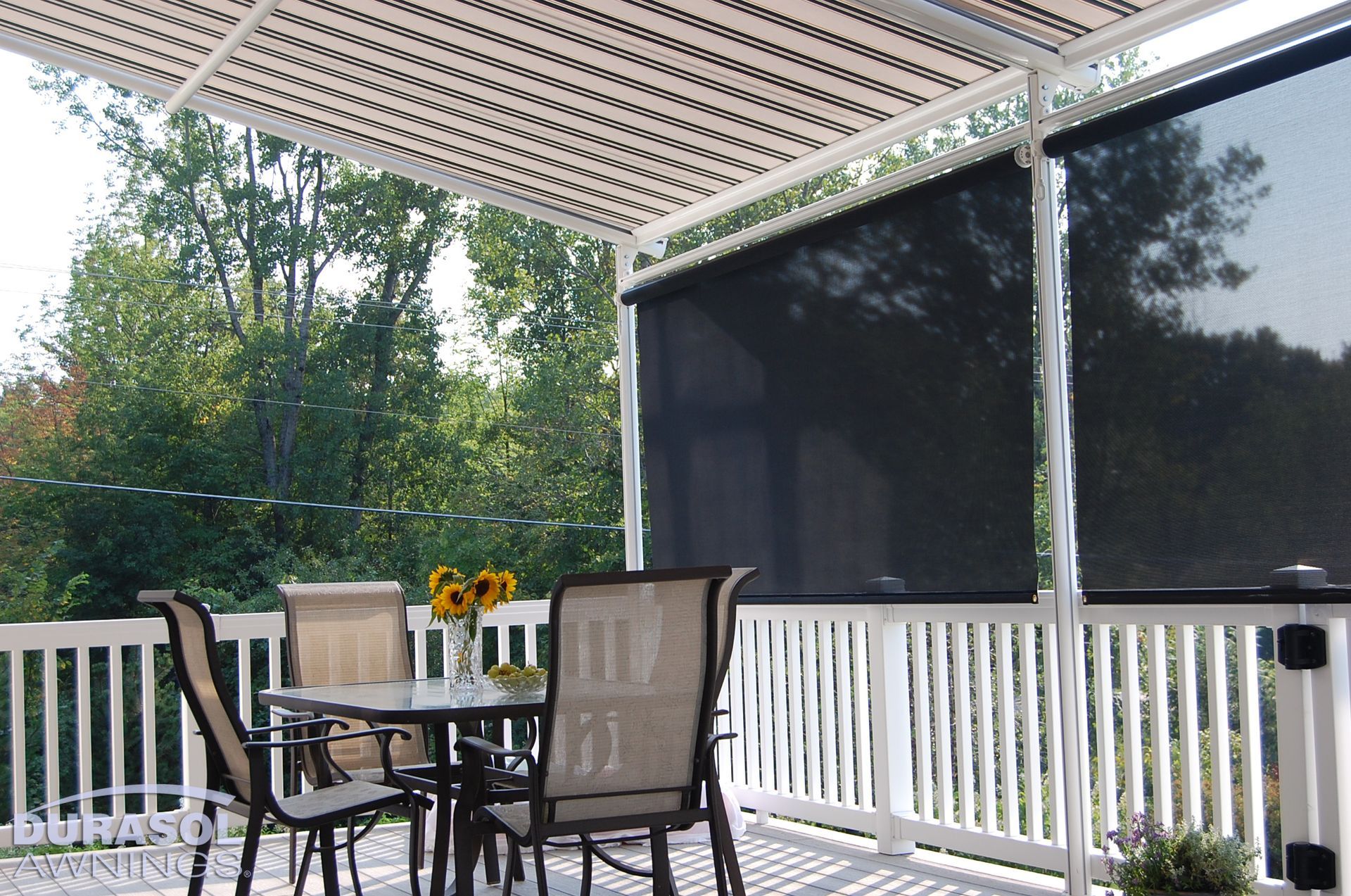A patio with a table and chairs under a brown canopy - Freehold, NJ - Awning Design Inc