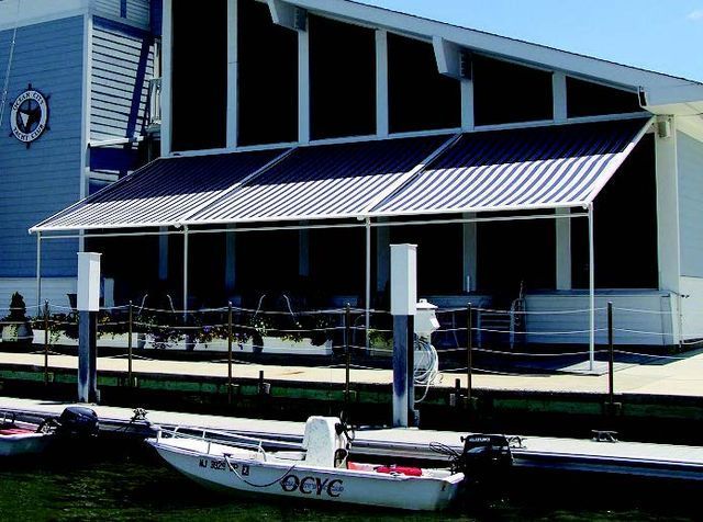 A boat that says ocve is docked in front of a building - Freehold, NJ - Awning Design Inc