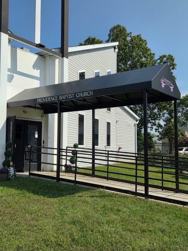 A patio with chairs and ottomans under an awning - Freehold, NJ - Awning Design Inc