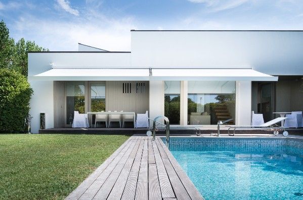 White retractable awnings over a pool.