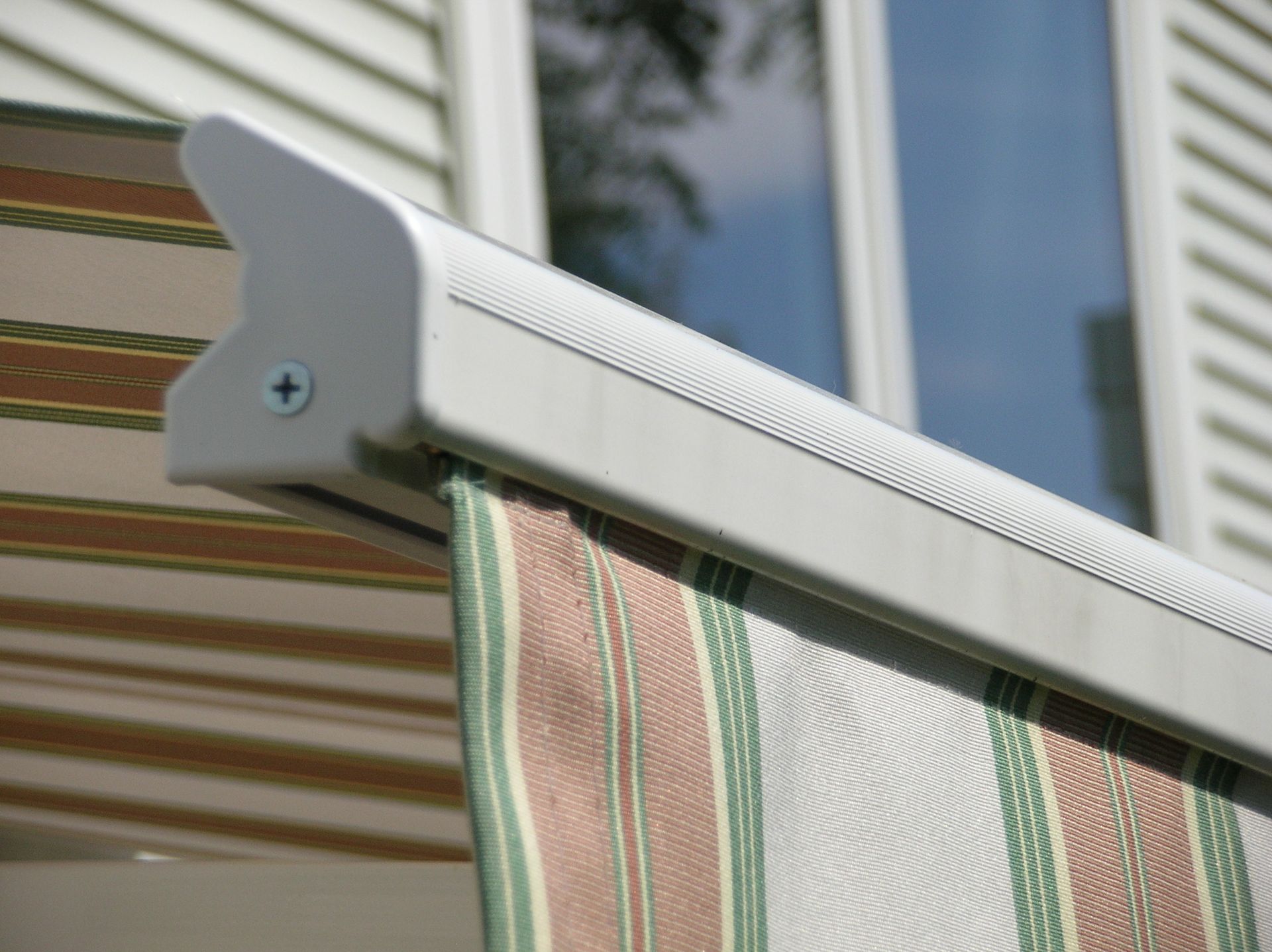 A close up of a striped awning on a window