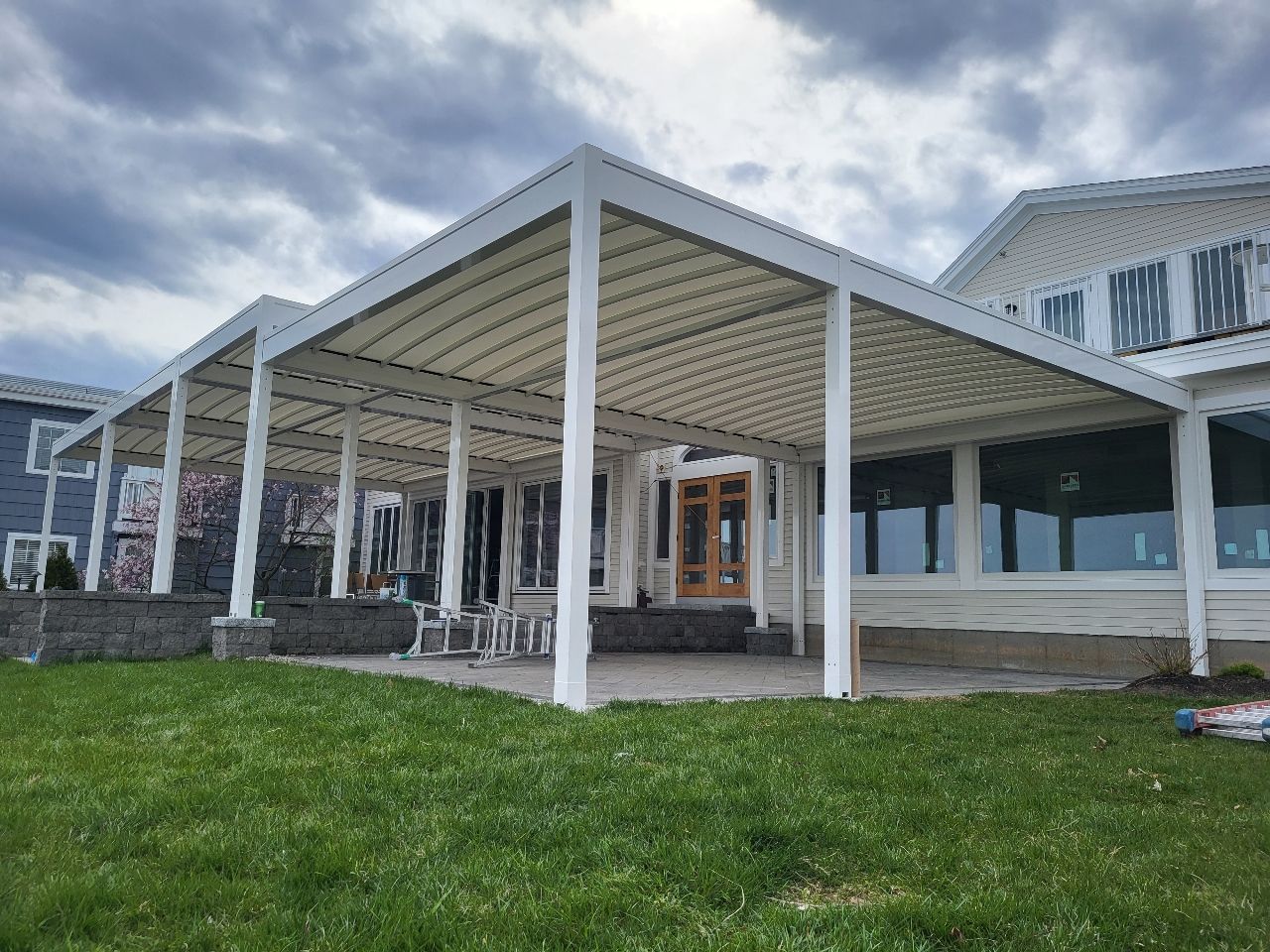 A large white house with a large covered patio in front of it - Freehold, NJ - Awning Design Inc