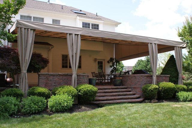 A large house with a large covered porch with curtains - Freehold, NJ - Awning Design Inc