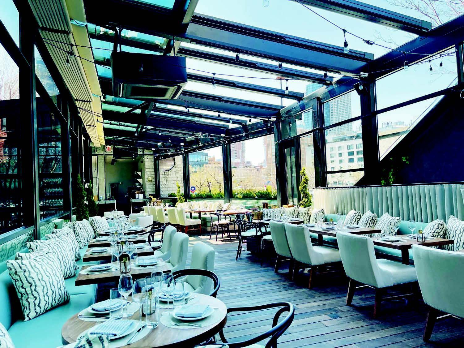 A restaurant with tables and chairs and a glass roof - Freehold, NJ - Awning Design Inc