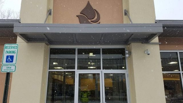 A building with a handicapped parking sign in front of it - Freehold, NJ - Awning Design Inc