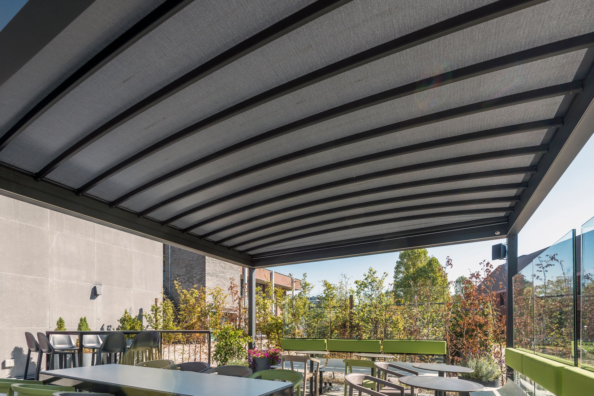 A pergola with tables and chairs underneath it - Freehold, NJ - Awning Design Inc