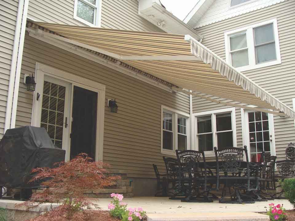 A patio with a table and chairs under an awning - Freehold, NJ - Awning Design Inc