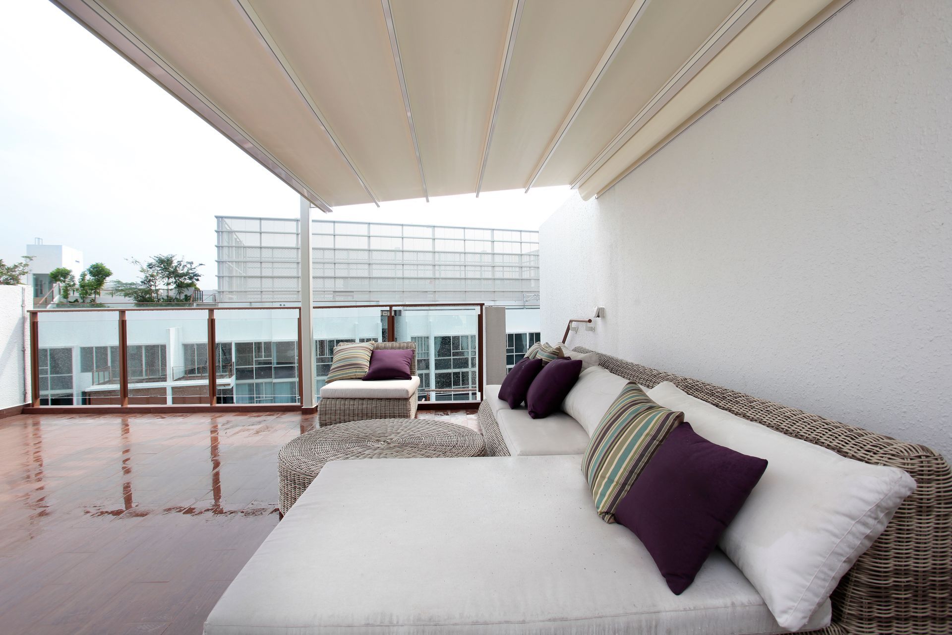A white couch with purple pillows sits on a balcony - Freehold, NJ - Awning Design Inc