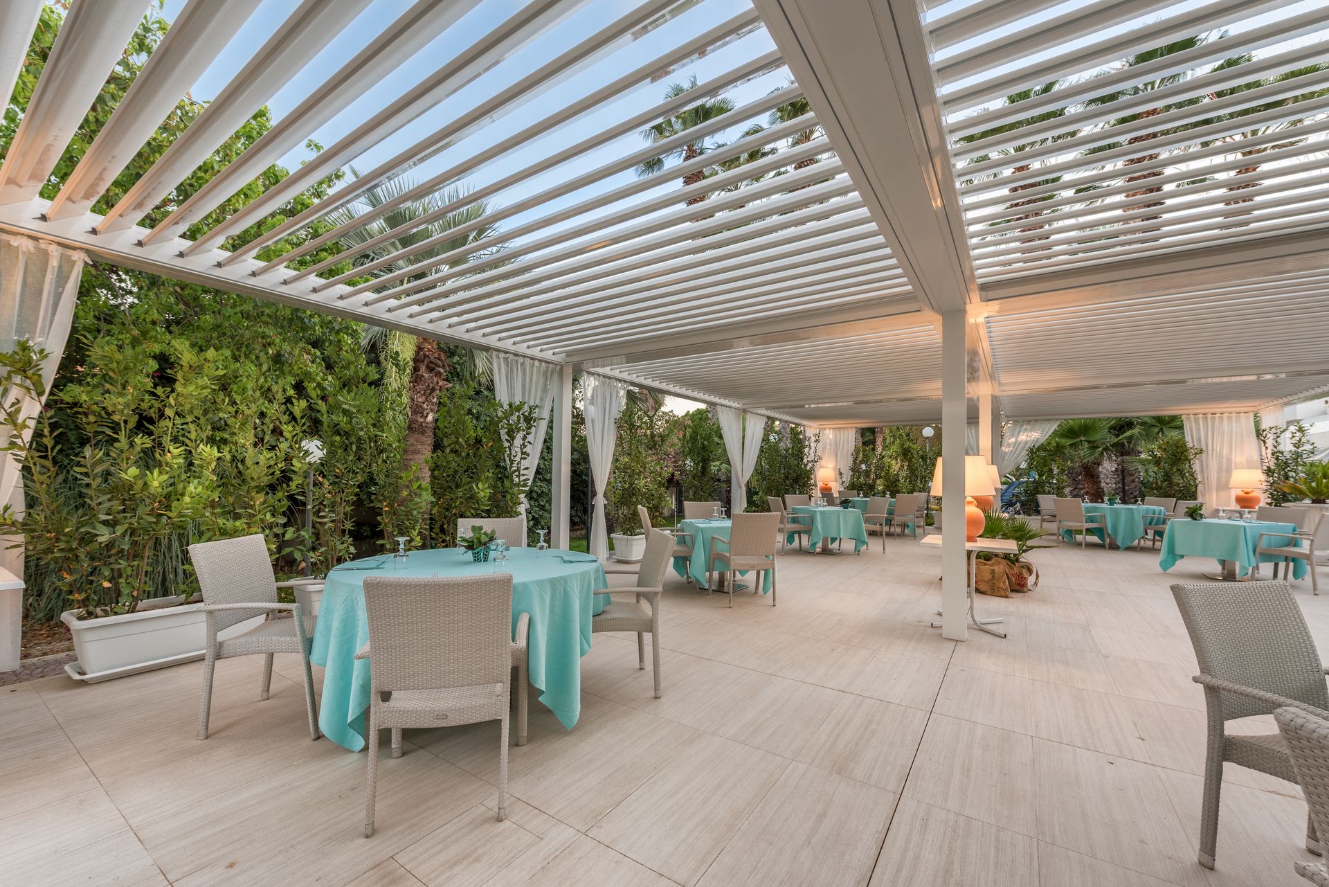 A patio with tables and chairs under a pergola - Freehold, NJ - Awning Design Inc