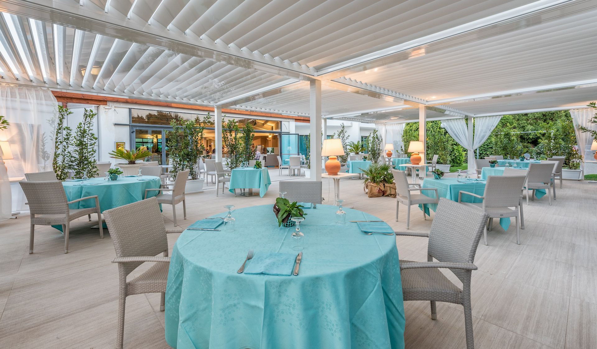 A restaurant with tables and chairs and a blue table cloth - Freehold, NJ - Awning Design Inc