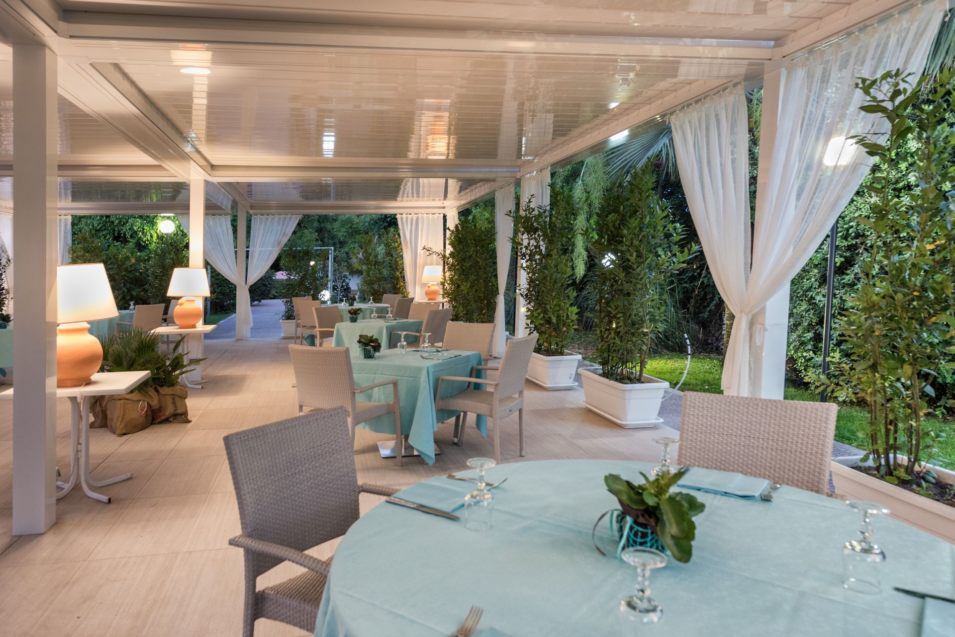 A restaurant with tables and chairs and a table with a plant on it - Freehold, NJ - Awning Design Inc