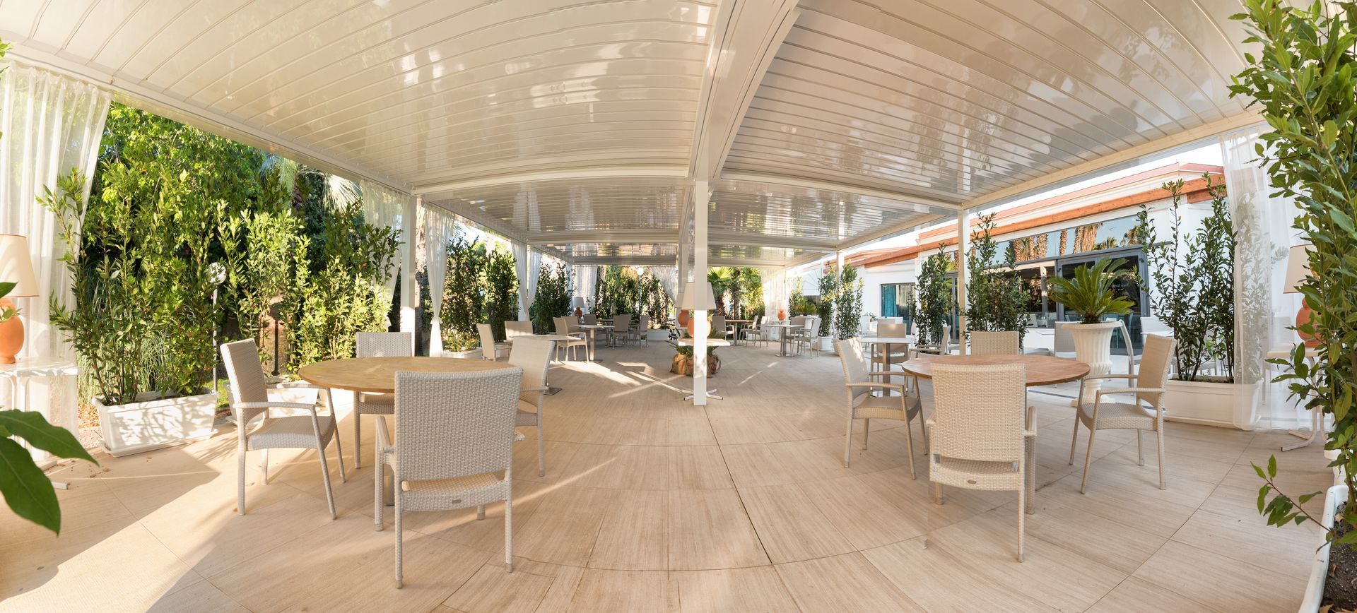 A large patio with tables and chairs under a canopy - Freehold, NJ - Awning Design Inc