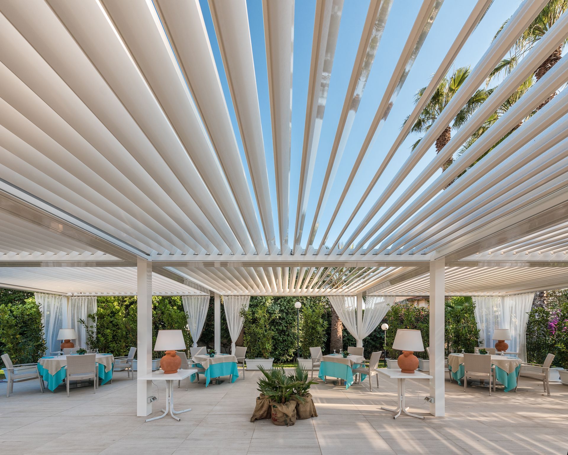 A white pergola with tables and chairs underneath it - Freehold, NJ - Awning Design Inc