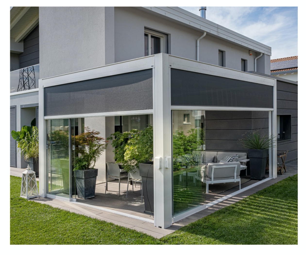 A house with a patio with a couch and chairs and potted plants - Freehold, NJ - Awning Design Inc