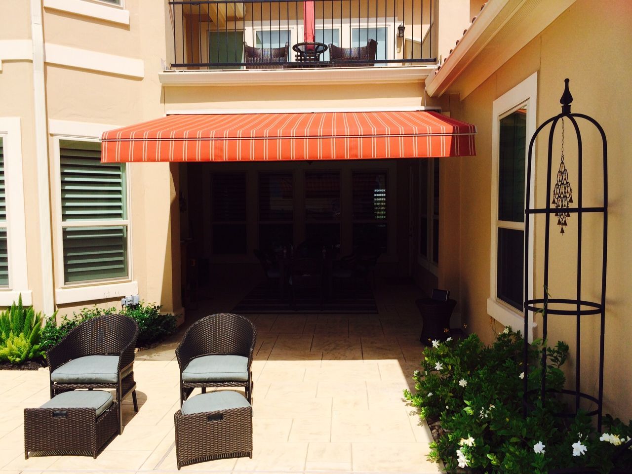 A patio with chairs and ottomans under an awning - Freehold, NJ - Awning Design Inc