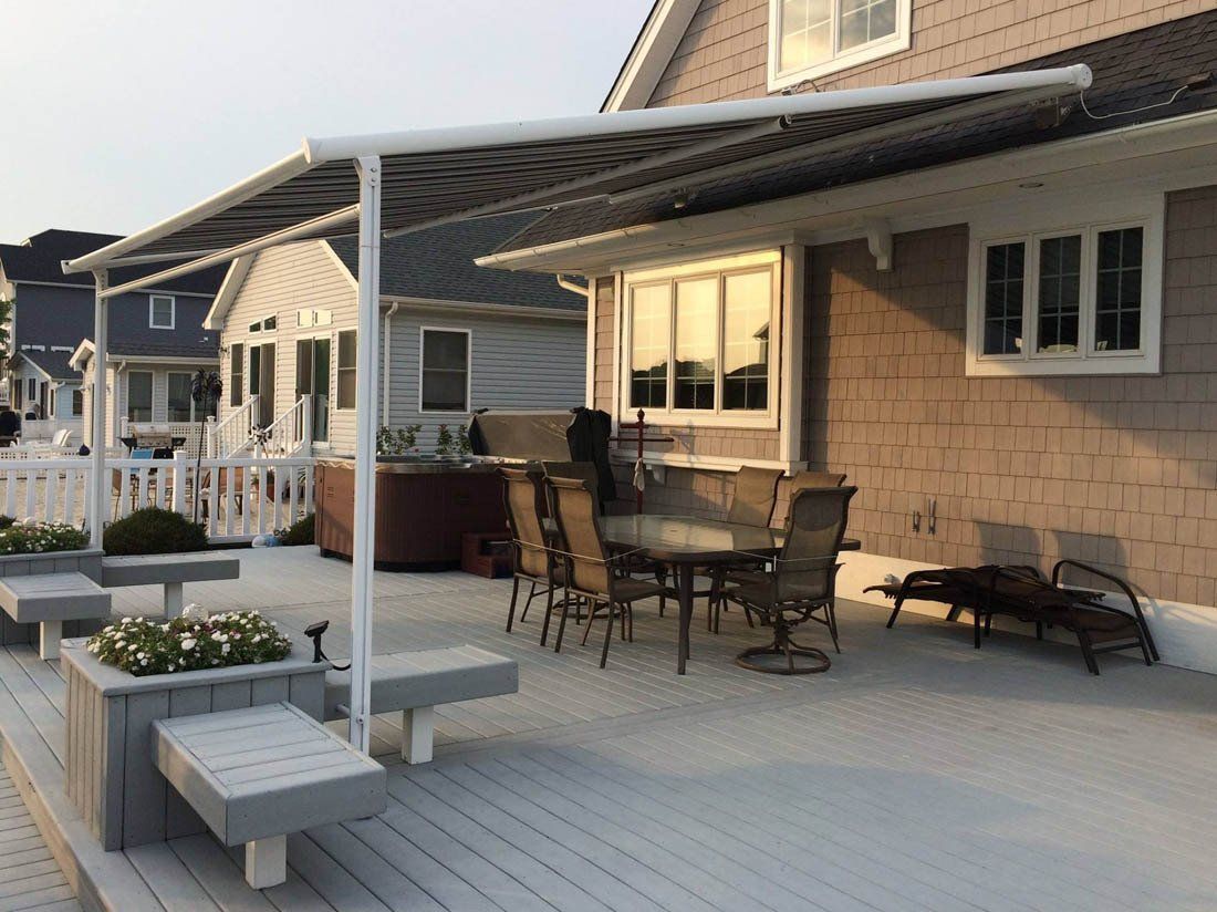 A patio with a table and chairs under a canopy.