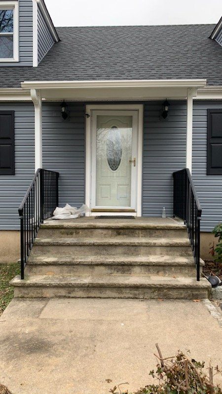 A blue house with a porch and steps leading to the front door - Freehold, NJ - Awning Design Inc