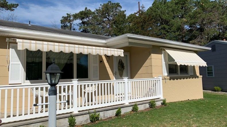 A house with a white awning on the front porch - Freehold, NJ - Awning Design Inc