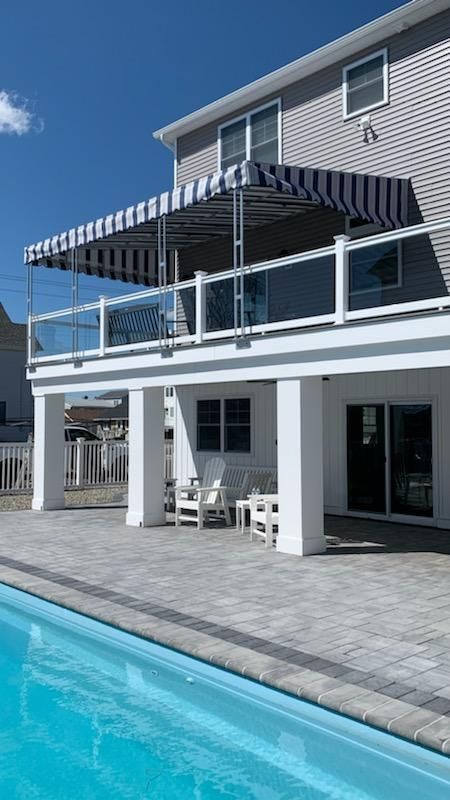 A large house with a swimming pool in front of it - Freehold, NJ - Awning Design Inc