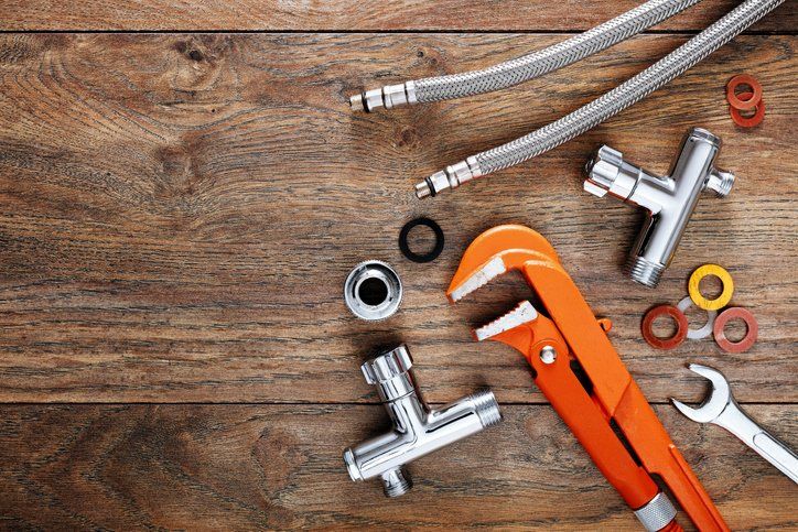 Set of plumbing tools on wooden table background