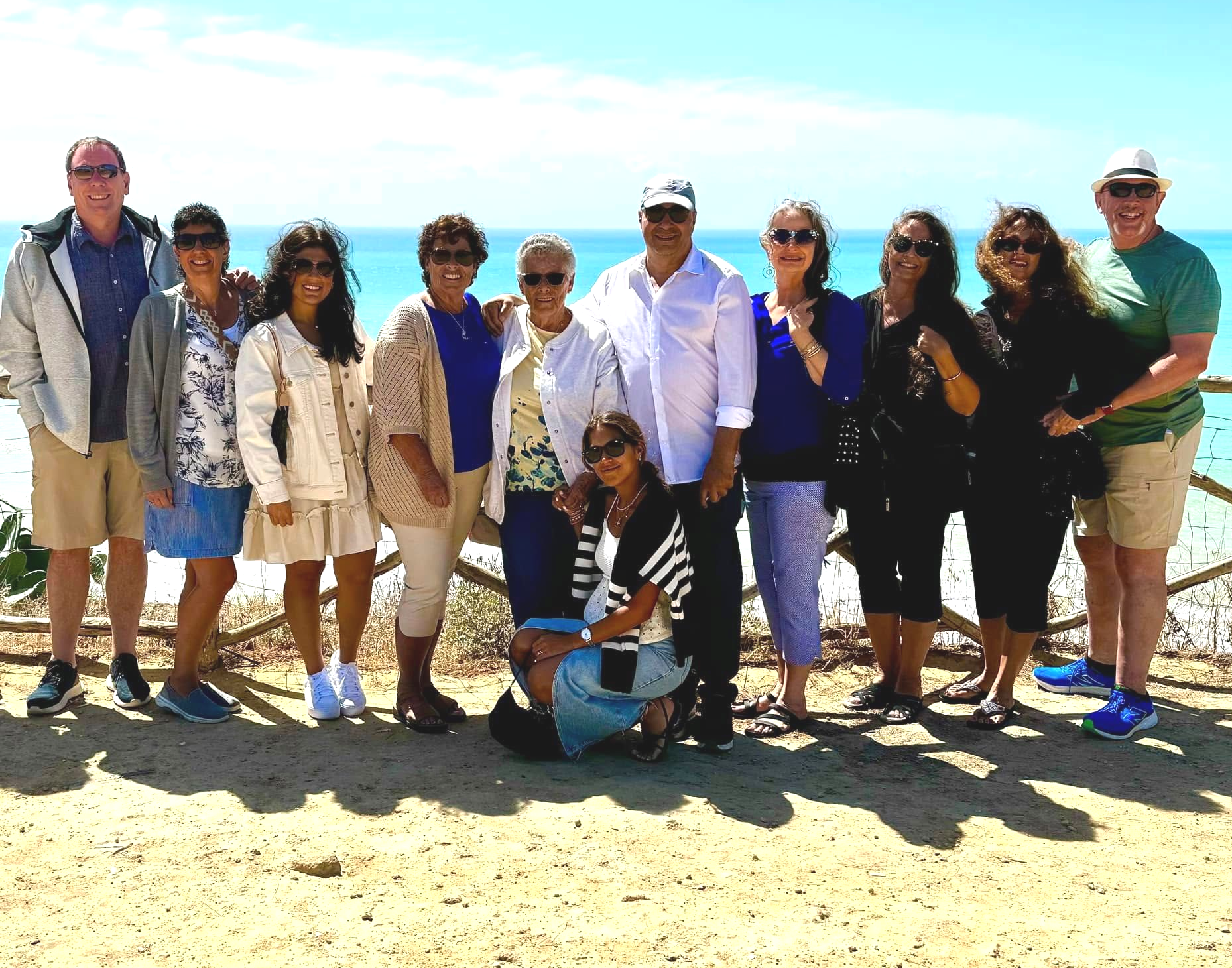 Couple in sunglasses relaxing in an infinity pool, ocean in background.