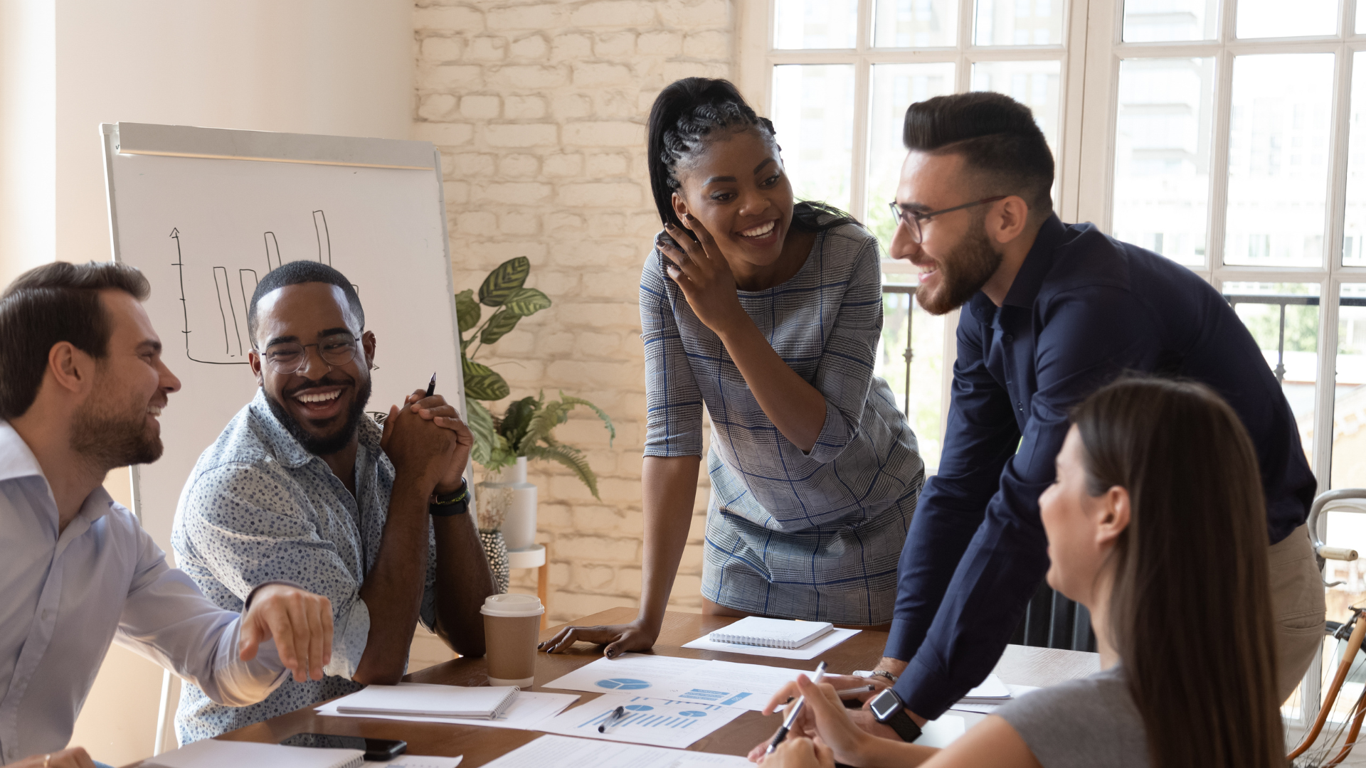 A group of people are sitting around a table having a meeting.