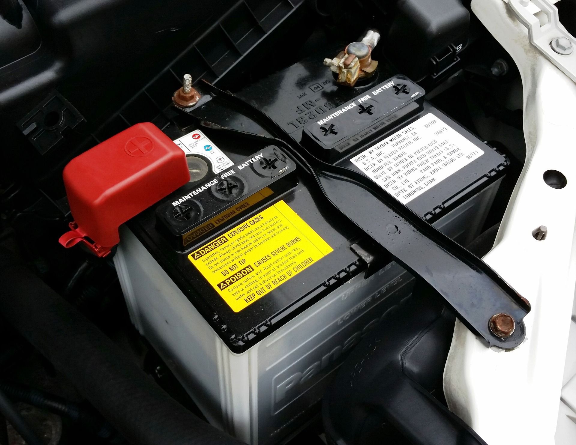 A close up of a car battery with a warning label on it