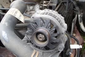 A close up of an alternator on a car engine.