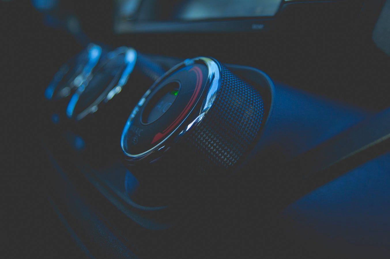 A close up of a car dashboard with a row of buttons.