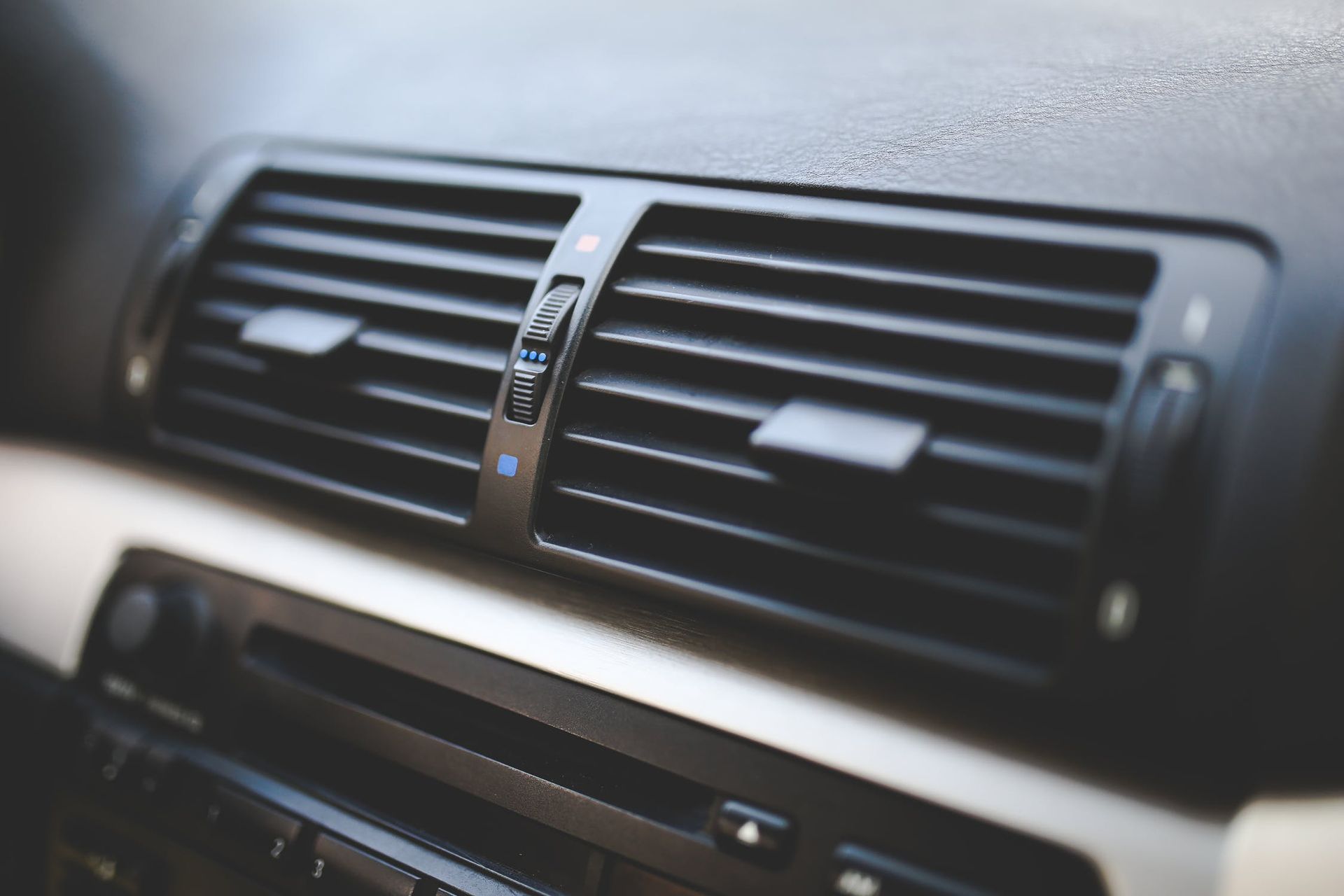 A close up of the air vents on the dashboard of a car.