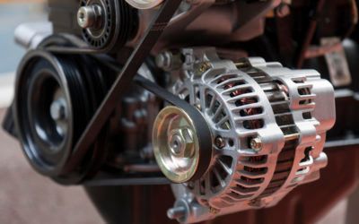 A close up of an alternator on a car engine.