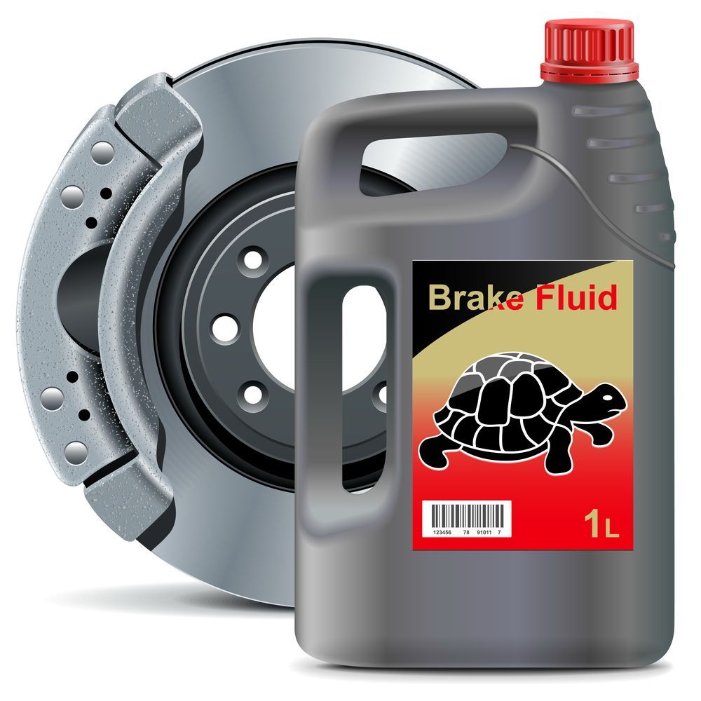 A bottle of brake fluid next to a brake disc