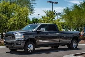 A black dodge ram truck is parked in a parking lot.