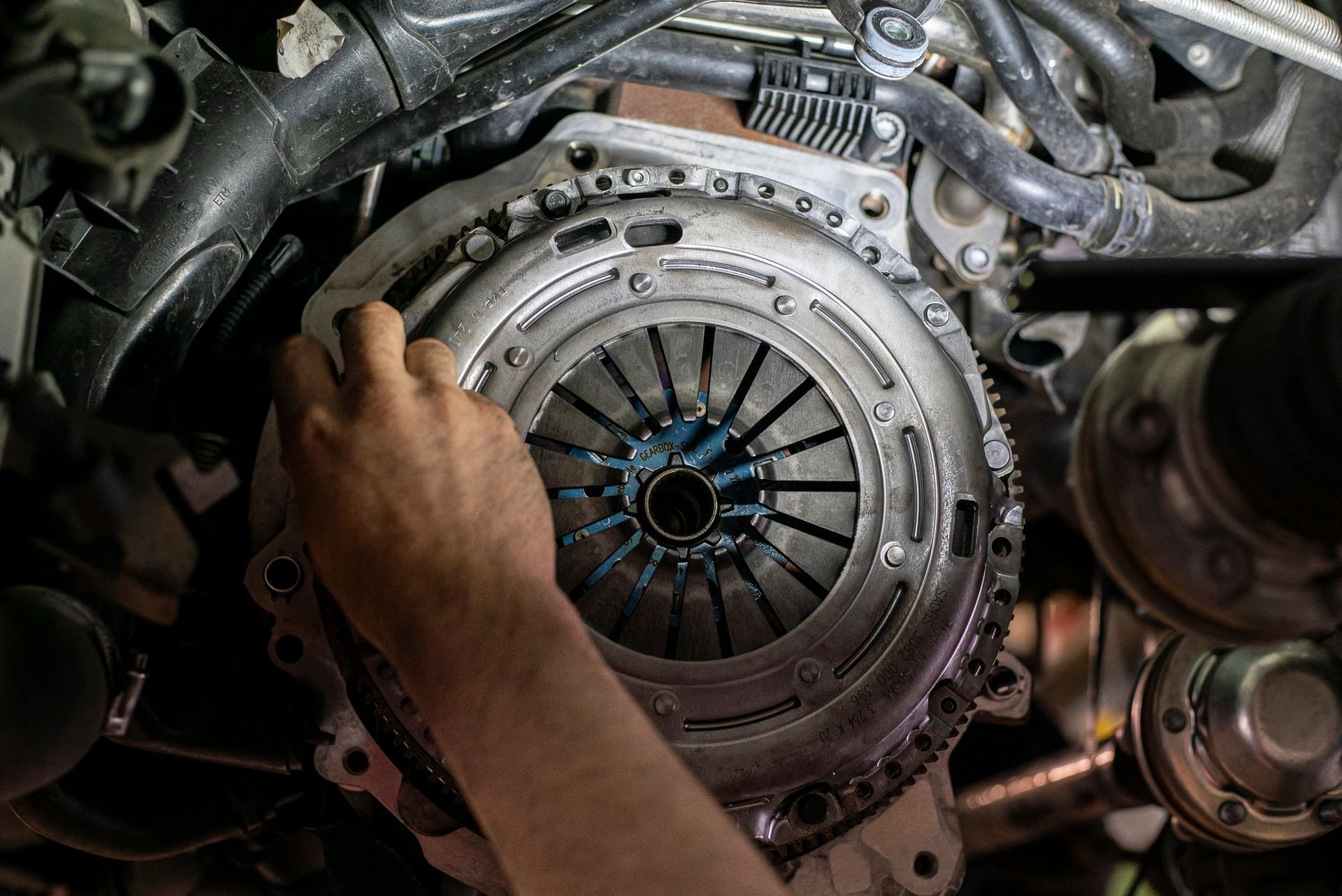 A person is fixing a clutch on a car engine.