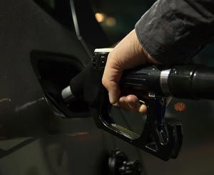 A person is pumping gas into a car at a gas station.