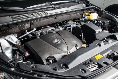 A close up of the engine of a car with the hood open.