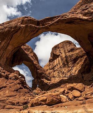A large rock arch in the middle of a desert.