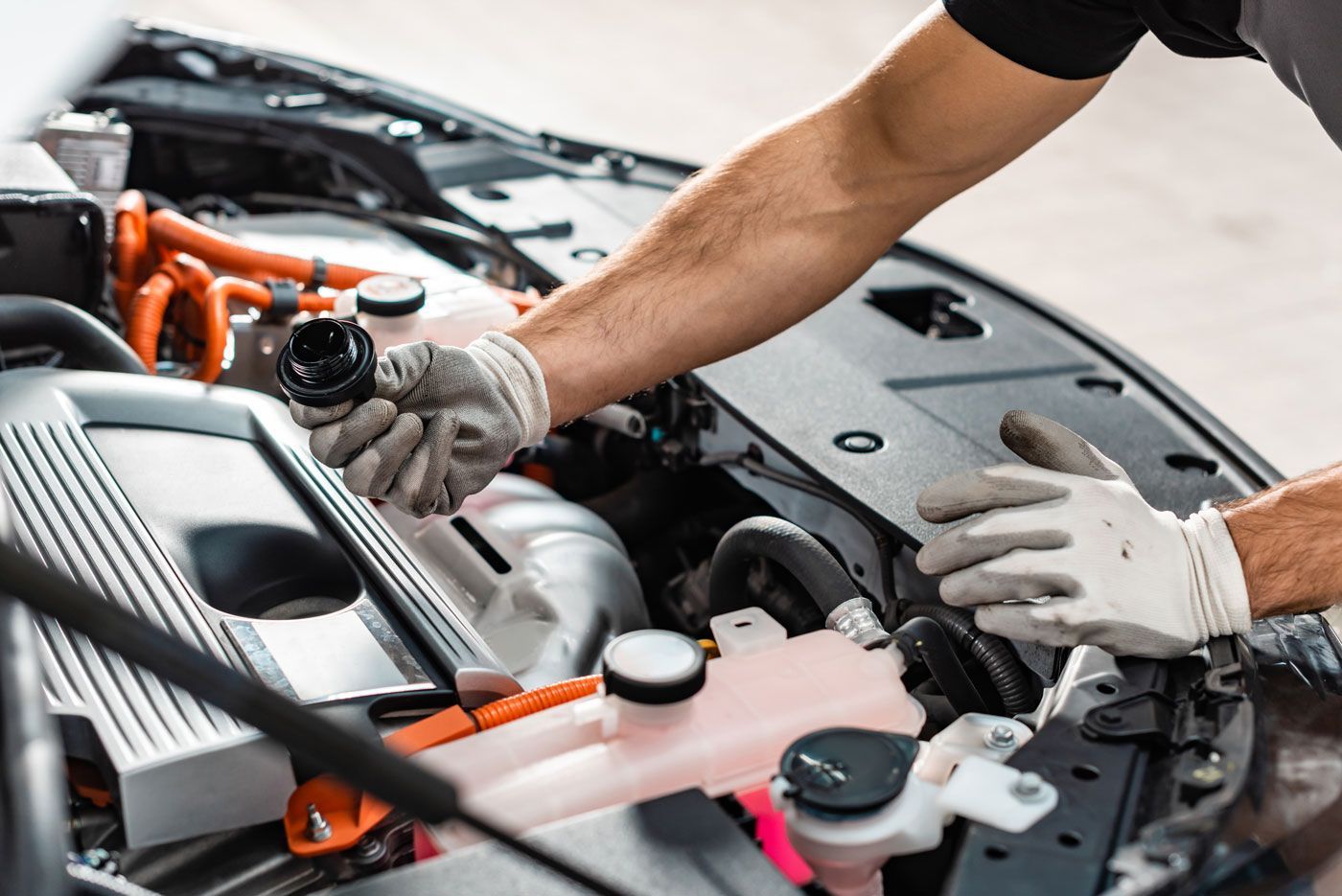 A man is working on the engine of a car.