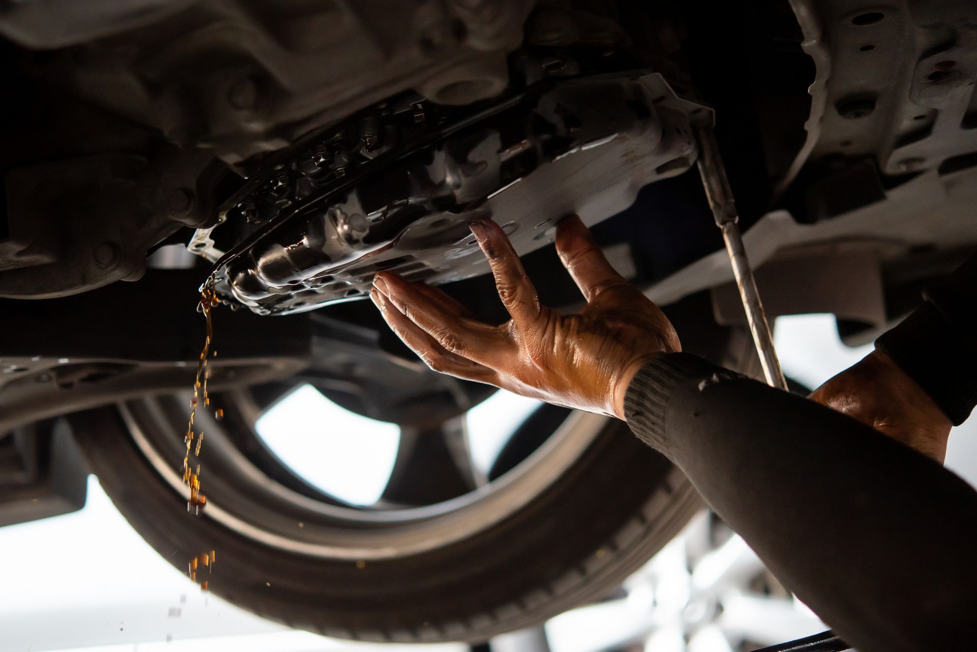 A person is changing the oil in a car.