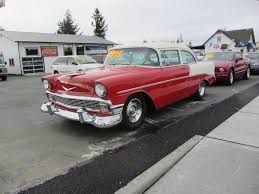 A red and white car is parked on the side of the road.