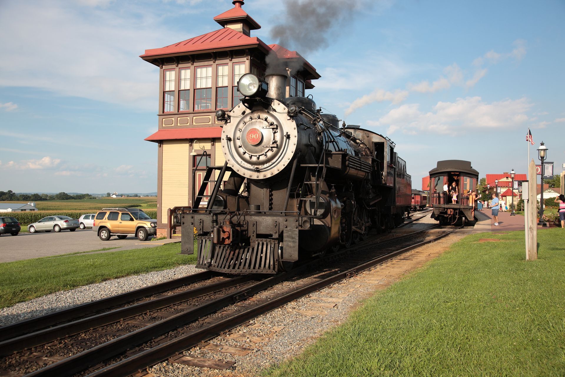 A train is pulling into a station with a red roof